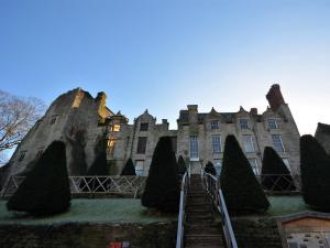 an old castle with trees in front of it at 1 bed in Crickhowell 42953 in Llangattock