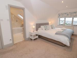 a bedroom with a bed and a window and a tub at Raleigh House in Salcombe