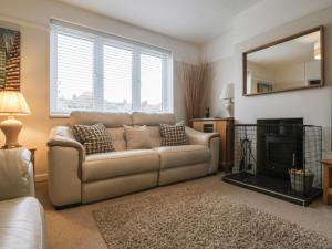 a living room with a couch and a fireplace at Holly Tree House in Herne Bay