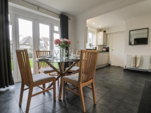 een eetkamer met een tafel en vier stoelen bij Holly Tree House in Herne Bay