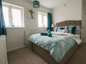 a bedroom with a bed with a teddy bear on it at Holly Tree House in Herne Bay