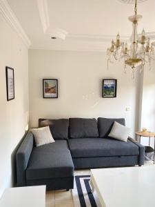 a living room with a blue couch and a chandelier at Zerrin Hanım Apartments - 1 minute from Kleopatra Beach in Alanya