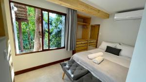 a bedroom with a bed and a large window at Loft novo em Morro de São Paulo in Morro de São Paulo