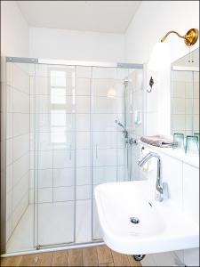a white bathroom with a sink and a shower at MARKT EINS Gästezimmer in Schöppenstedt
