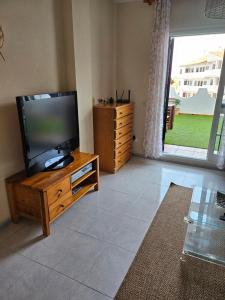 a living room with a flat screen tv on a wooden entertainment center at Apartamento en Mijas con Terraza, capacidad para 5 personas in Málaga