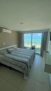 1 dormitorio con cama y vistas al océano en Flat Manaíra Palace, en João Pessoa