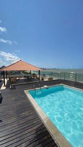 una piscina en una terraza junto al océano en Flat Manaíra Palace, en João Pessoa