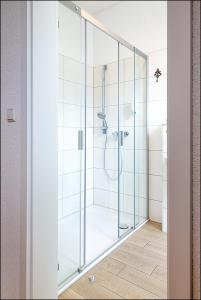 a shower with a glass door in a bathroom at MARKT EINS Gästezimmer in Schöppenstedt