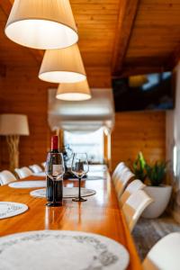 une longue table en bois avec deux verres de vin dans l'établissement Domek Rychwałdówka blisko jeziora Żywieckiego, à Rychwałd