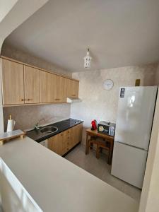 a kitchen with a white refrigerator and wooden cabinets at Apartamento en Mijas con Terraza, capacidad para 5 personas in Málaga