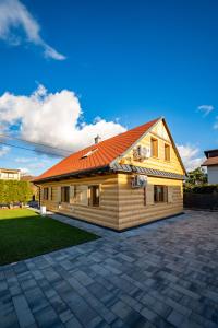 une maison au toit orange avec une allée en briques dans l'établissement Domek Rychwałdówka blisko jeziora Żywieckiego, à Rychwałd