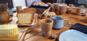 ein Tisch mit Brot und Tassen Kaffee drauf in der Unterkunft La Maison des Maîtres de Forge in Moloy