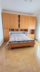 - une chambre avec un lit et des placards en bois dans l'établissement Savena House, à Bologne