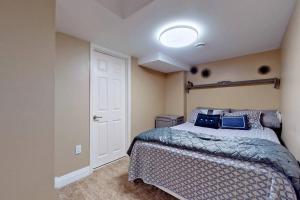a bedroom with a bed with blue pillows on it at 3 Bedroom Apartment for up to 6 with 2 bathrooms in Pickering
