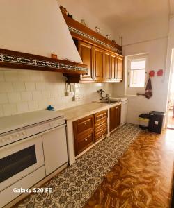 uma cozinha com armários de madeira e um forno de fogão branco em Casa Gavina paseo marítimo de Altea em Altea