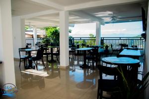 a restaurant with tables and chairs on a balcony at J&G Villa Hotel in Cap-Haïtien