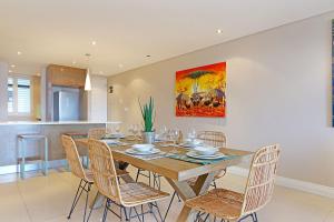a dining room with a table and chairs at Eden On The Bay 172 by HostAgents in Bloubergstrand