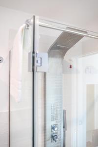 Una puerta de cristal en el baño con ducha. en HAPPYROOMS, en Bacoli