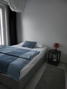 a bedroom with a bed with blue sheets and a window at Easy stay in Tampere
