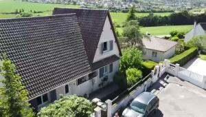 Vista árida de una casa con un coche aparcado en la entrada en Vaste maison de charme a proximité de Versailles et Paris, en Beynes