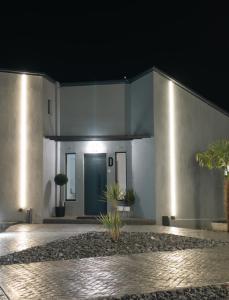 a white building with a blue door at night at THE ROOMS in Kato Loutraki