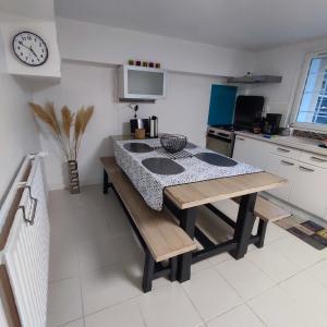 una cocina con mesa y fregadero. en Une - Halte Entre Les Ponts - en toute simplicité en Saumur