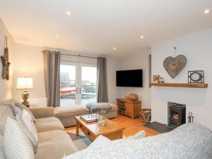 a living room with a couch and a fireplace at Laneton in Rhosneigr