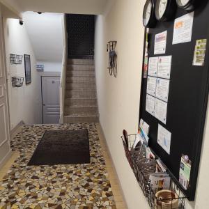 a hallway with a tile floor and a staircase at Une - Halte Entre Les Ponts - en toute simplicité in Saumur