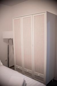 a bedroom with white cabinets and a bed at Maria's Premium Suite in Baia Mare
