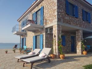 a building with two chaise lounges in front of it at Fanaraki villas 2 in Moudhros