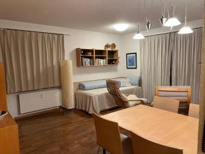 a living room with a couch and a table in a room at 2-Zimmer Studio mit grossem Balkon und Bergpanorama - 400m von Talstation Sillerenbahn in Adelboden