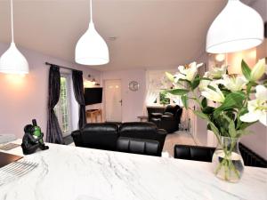 a kitchen and living room with a table and flowers at 1 bed in Beccles 65080 in Beccles