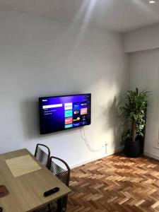 Zimmer mit einem Tisch und einem TV an der Wand in der Unterkunft 2 ambientes, Rosedal de Palermo y embajada EEUU in Buenos Aires