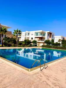 una gran piscina frente a un edificio en appartement vue sur piscine et montagne imi ouadar taghazout, en Taghazout