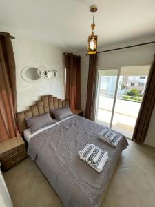 a bedroom with a bed with two pillows on it at appartement vue sur piscine et montagne imi ouadar taghazout in Taghazout