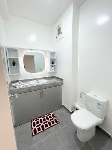 łazienka z białą toaletą i umywalką w obiekcie appartement vue sur piscine et montagne imi ouadar taghazout w mieście Taghazout