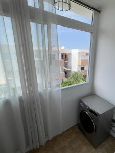 łazienka z oknem i pralką w obiekcie appartement vue sur piscine et montagne imi ouadar taghazout w mieście Taghazout