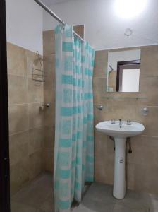 La salle de bains est pourvue d'un lavabo et d'un rideau de douche. dans l'établissement Departamento Costanera Alta Gracia, à Alta Gracia
