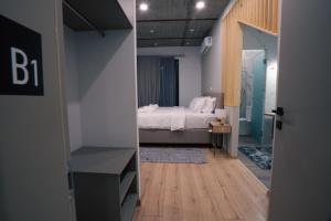 a bedroom with a bed and a room with a hallway at THE ROOMS in Kato Loutraki