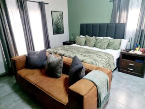 ein Schlafzimmer mit einem großen Bett und einem Sofa in der Unterkunft Wild Fig Rest Guest House in Polokwane