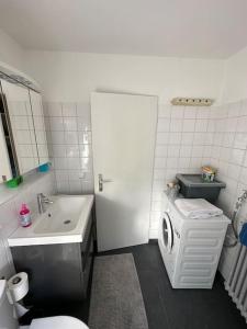 a bathroom with a sink and a washing machine at Double Bed Apartment - Near Marienplatz in Stuttgart