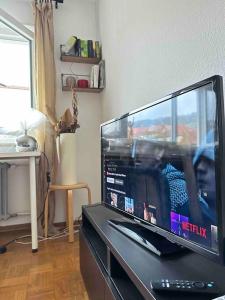 uma grande televisão de ecrã plano sentada num centro de entretenimento em Double Bed Apartment - Near Marienplatz em Estugarda