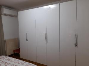 - une chambre avec des placards blancs et un lit dans l'établissement INALPI ARENA ex Pala Alpitour-STADIO OLIMPICO - Luxury Apartment Virgilio - Santa Rita, à Turin