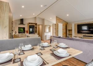 a dining room table with plates and wine glasses at Grange Leisure Park in Mablethorpe