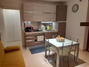 une cuisine avec une table et des chaises ainsi qu'une cuisine avec une cuisinière dans l'établissement INALPI ARENA ex Pala Alpitour-STADIO OLIMPICO - Luxury Apartment Virgilio - Santa Rita, à Turin