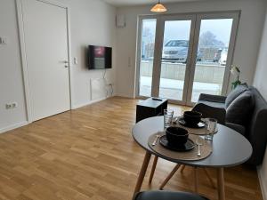a living room with a table and a couch at Modernes Apartment I Parkplatz I Terrasse in Blumberg