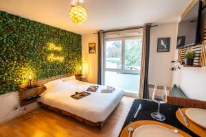 ein Schlafzimmer mit einem Bett mit einer grünen Wand in der Unterkunft Cabana & Merci Annecy - Parking et Proche du Lac in Annecy