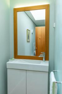 a bathroom with a mirror over a white sink at The View in Ponta Delgada +52 photos