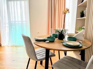 mesa de comedor con sillas y ordenador portátil en Stylish Apartment Getaway with self check-in, en Arad