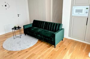 a green couch in a living room with a table at Stylish Apartment Getaway with self check-in and free parking lot in Arad +19 photos